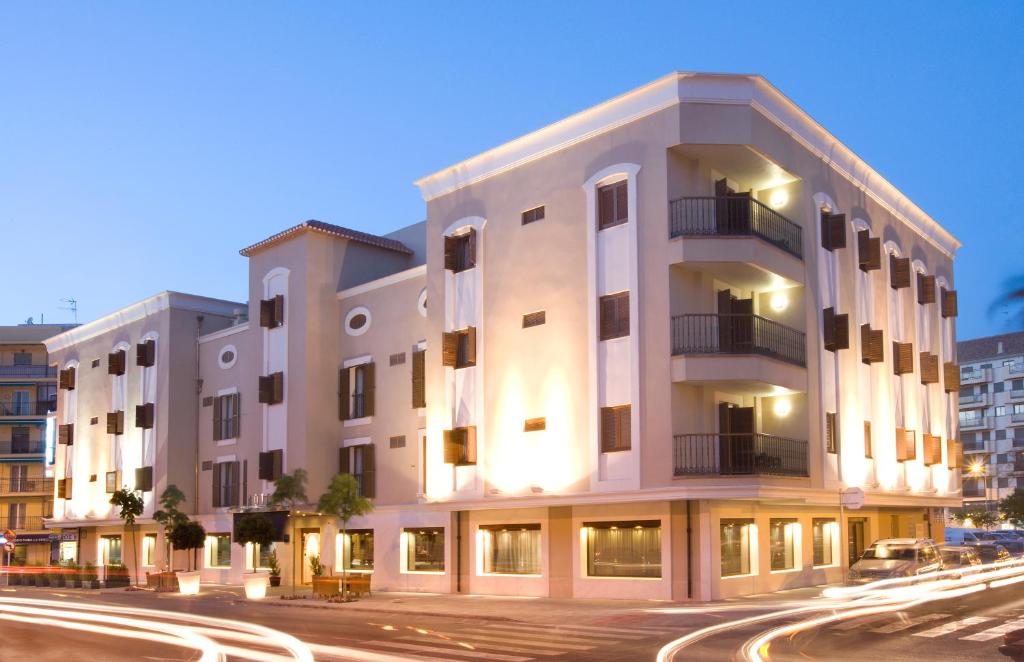 a large white building on a city street at night at Hotel MR Costa Blanca in Denia