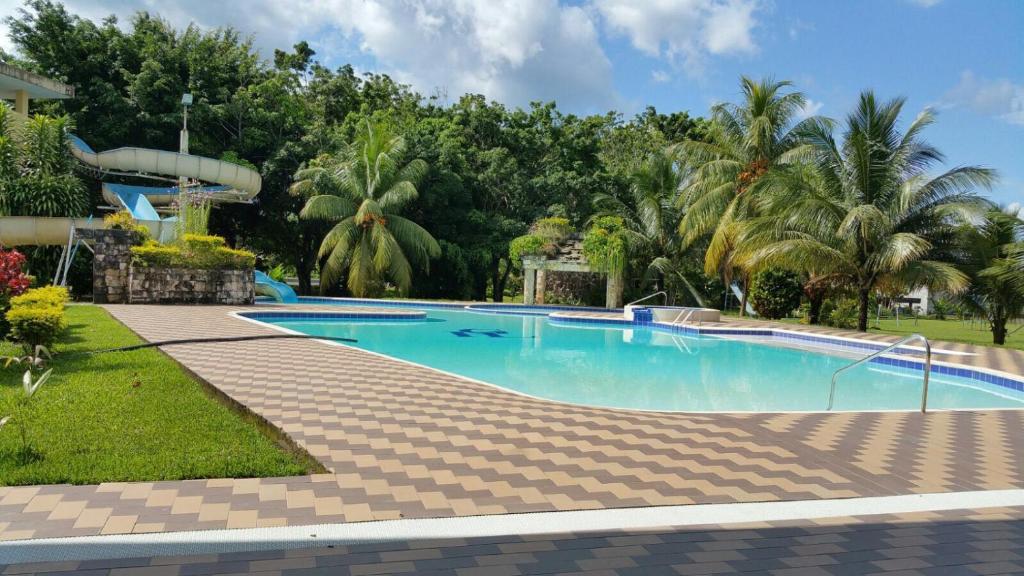 a swimming pool in a resort with palm trees at Gran Hotel De Lago - Lago Agrio in Nueva Loja