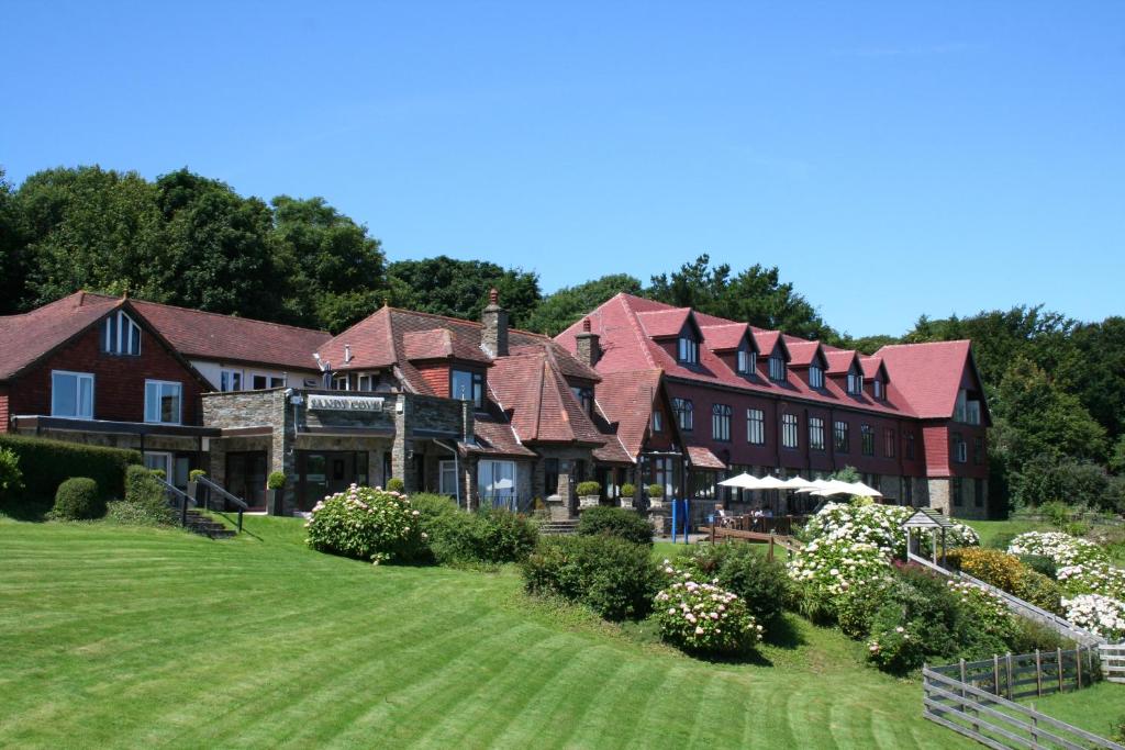 a large building on a green field with trees at Sandy Cove Hotel in Ilfracombe
