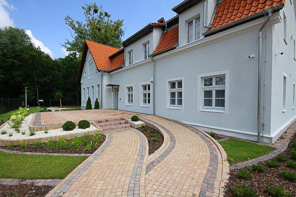 a brick driveway leading to a white house at Willa Park Apartamenty in Olsztyn