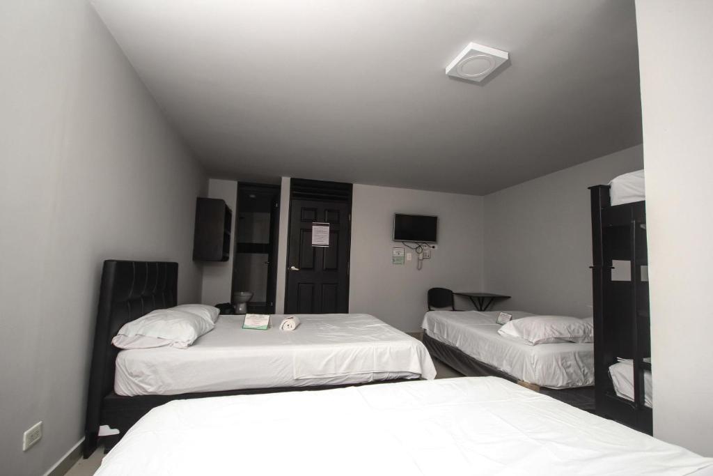 Postel nebo postele na pokoji v ubytování Hotel Escorial Ibagué