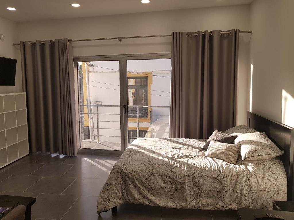 プライア・ダ・ヴィトーリアにあるBlack Houseのベッドルーム1室(ベッド1台付)、スライド式ガラスドアが備わります。