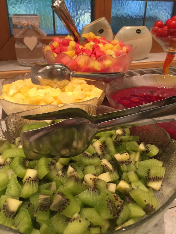 a tray of fruit with a serving spoon on top at Hotel Styrolerhof in Steeg