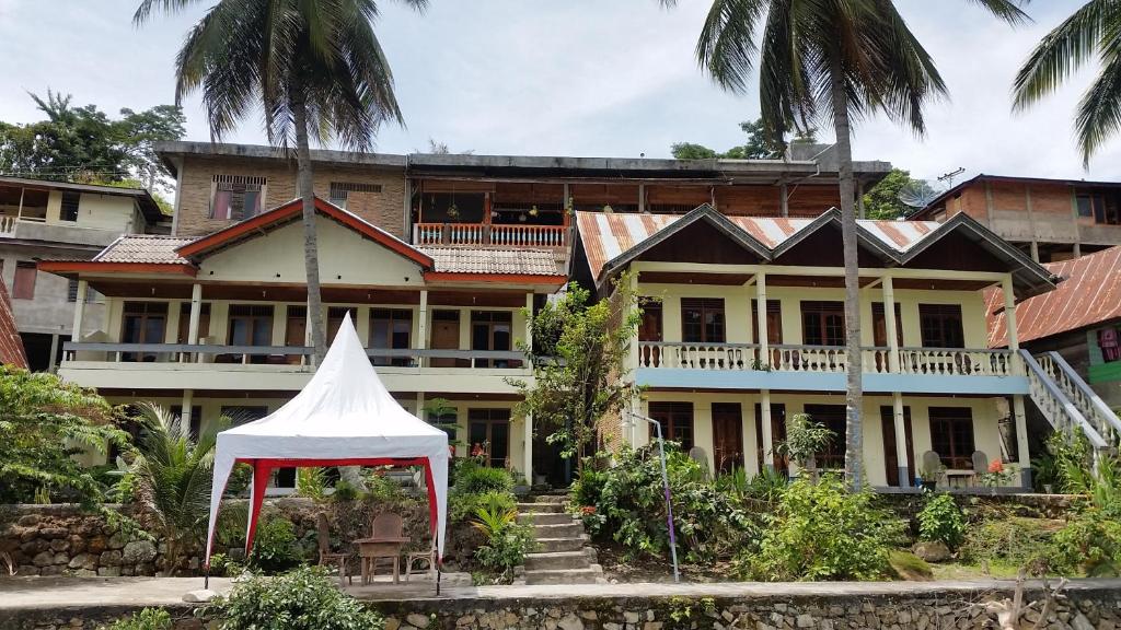 een groot huis met een witte tent ervoor bij Sibayak Guesthouse in Tuk Tuk