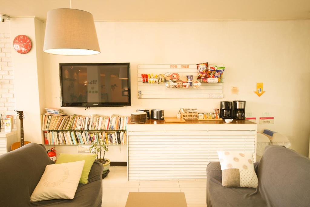 a living room with two couches and a flat screen tv at Yeha Guesthouse in Jeju