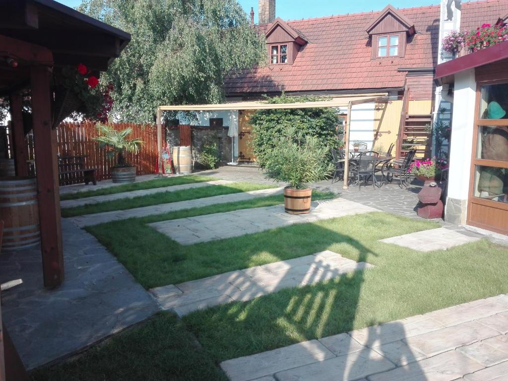 een tuin met een patio en een huis bij Hostinec a penzion Dolní Dvůr in Veřovice