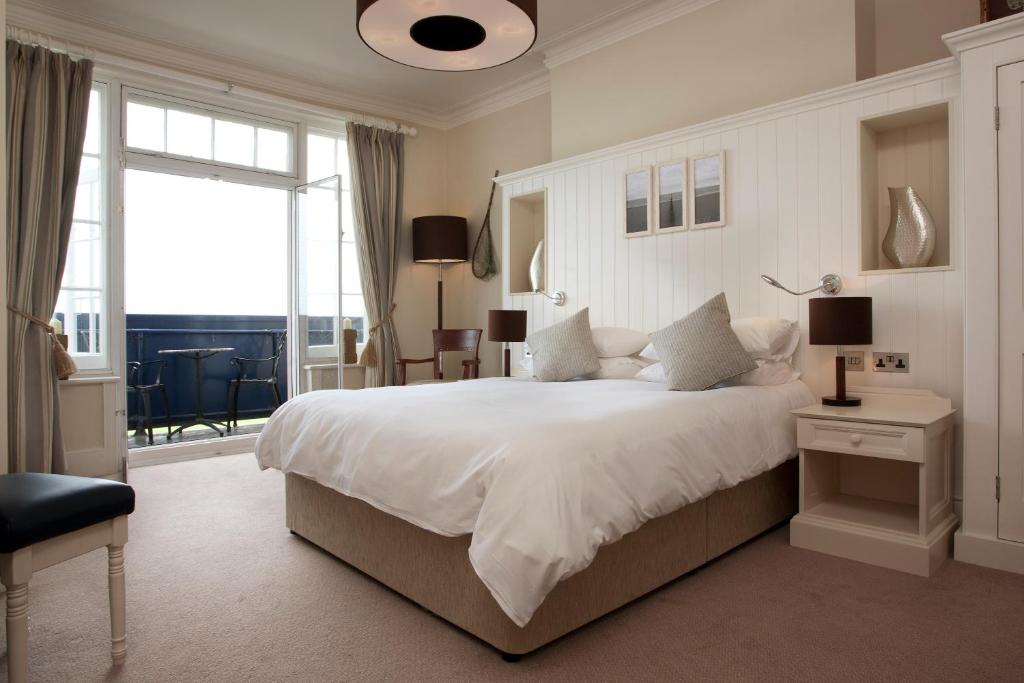 a bedroom with a large bed and a large window at The Marine in Whitstable