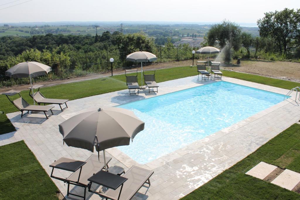an overhead view of a swimming pool with chairs and umbrellas at Poggio di Pastrengo in Pastrengo