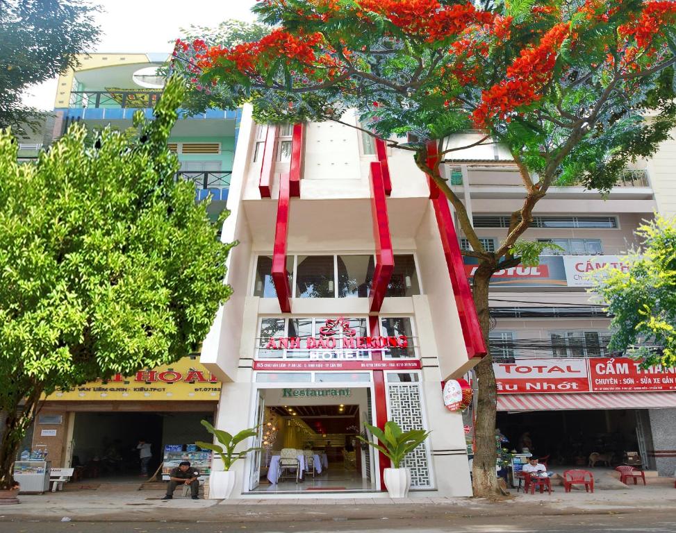 un edificio bianco con nastri rossi appesi ad esso di Anh Dao Mekong Hotel a Can Tho