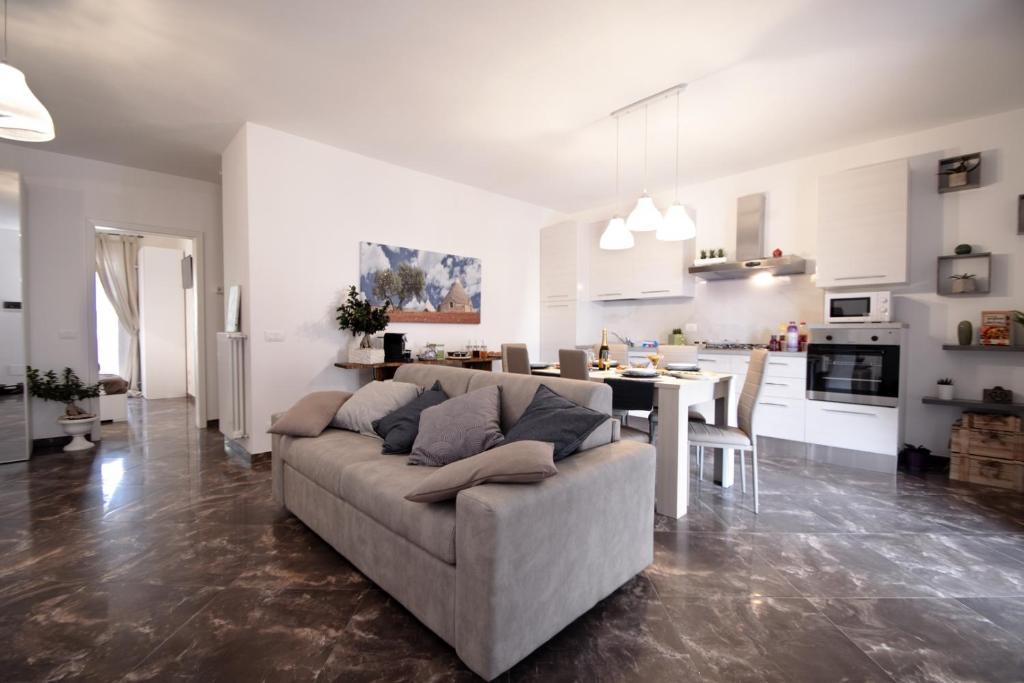 Una sala de estar y una cocina con un sofá y una mesa. en Terra di Levante, en Mola di Bari