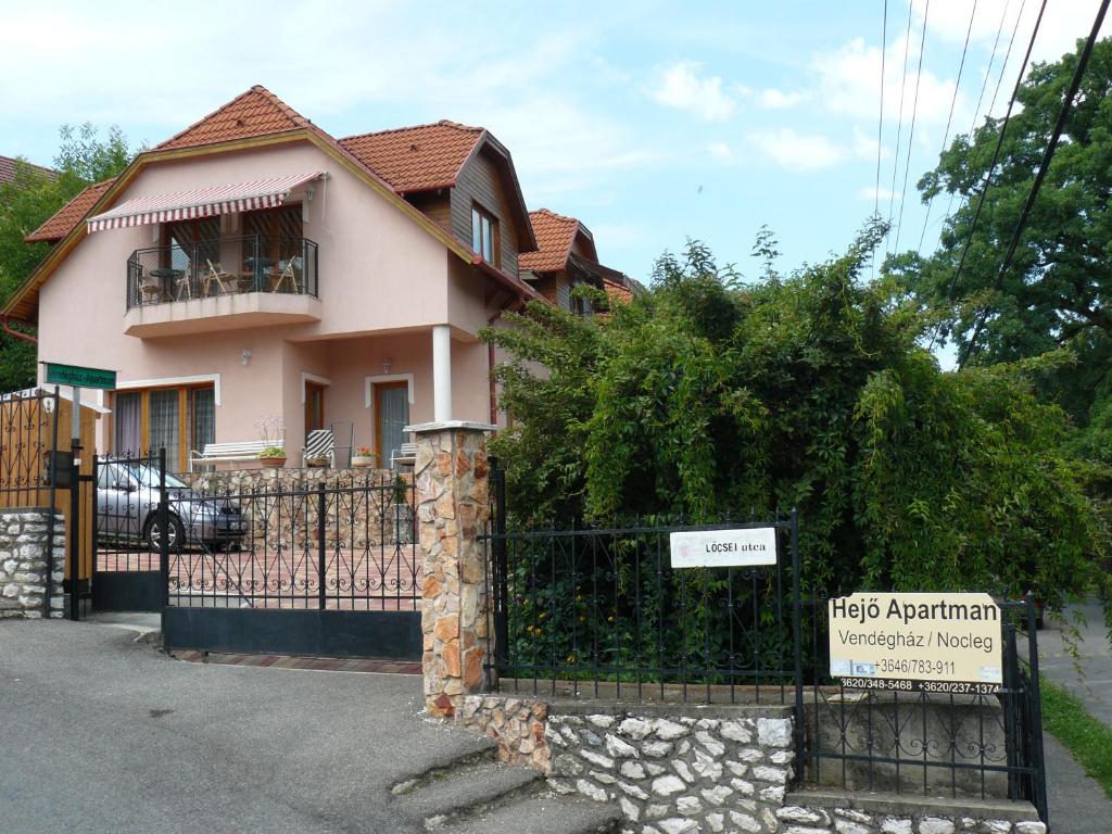 a house with a gate with a sign in front of it at Hejő Apartman in Miskolctapolca