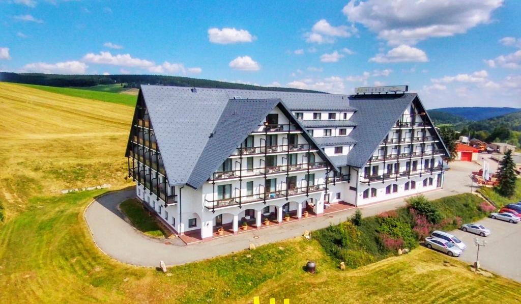 eine Luftansicht eines großen Gebäudes auf einem Feld in der Unterkunft Alpina Lodge Hotel Oberwiesenthal in Kurort Oberwiesenthal