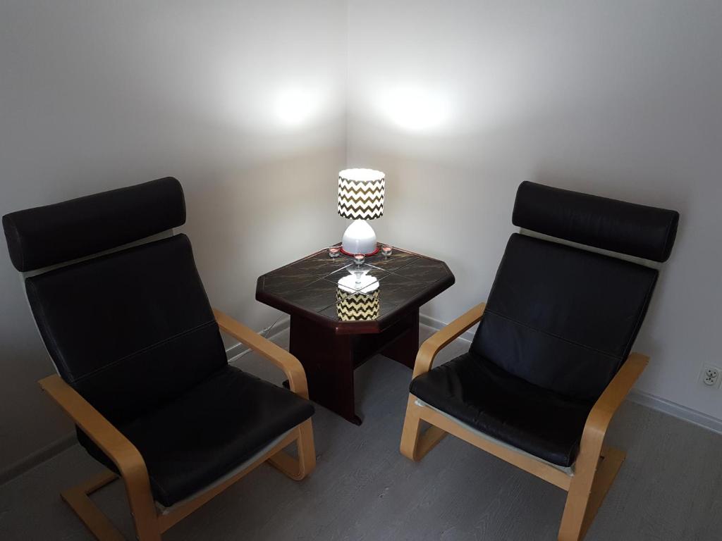 two chairs sitting next to a table with a lamp at Apartment Gdańsk Wrzeszcz in Gdańsk