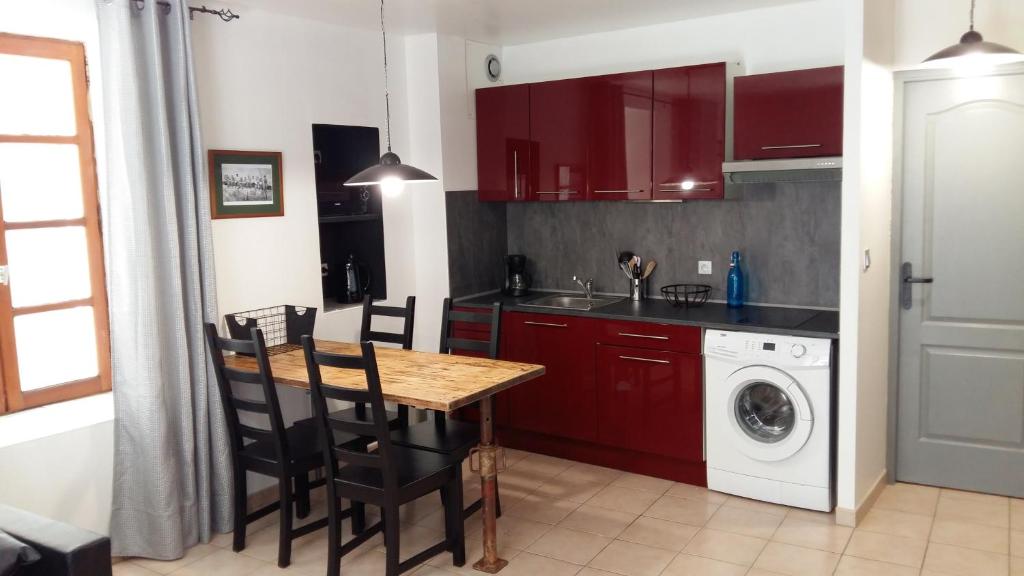 a kitchen with a table and a washing machine at Appartement Belle Croix in Avignon
