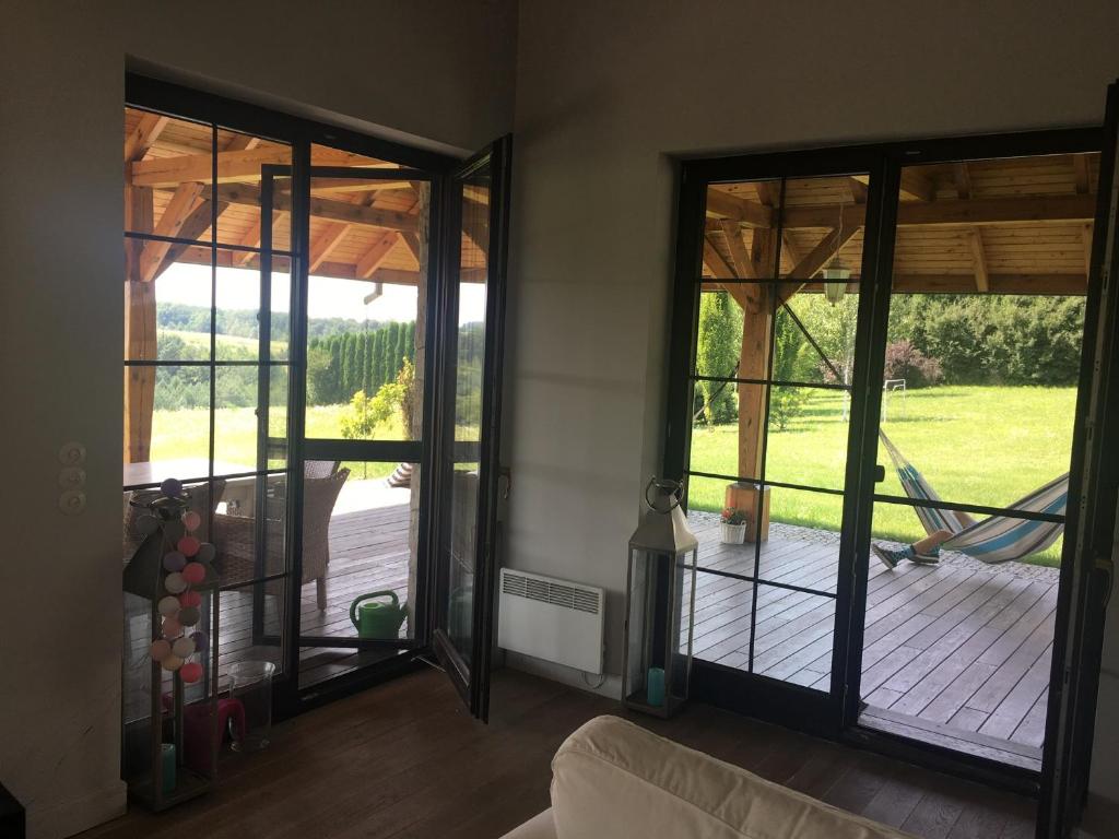 a living room with sliding glass doors and a hammock at Villa Okale in Kazimierz Dolny