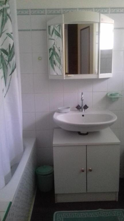 a bathroom with a sink and a tub and a mirror at La Grange in Le Plan