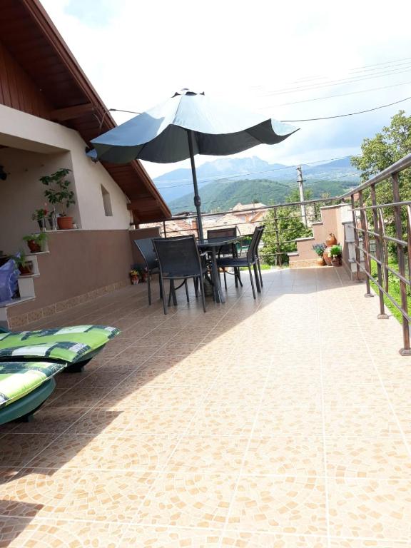 a balcony with a table and an umbrella at Casa Delia in Călimăneşti