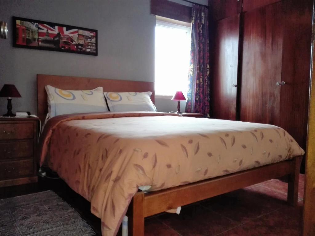 een slaapkamer met een groot bed en een raam bij Arrifana Summer Flat in Aljezur