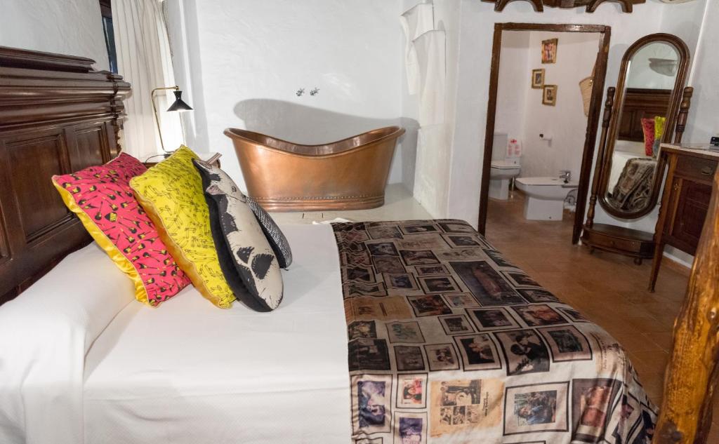 a bedroom with a bed and a bathroom with a tub at Pikes Ibiza in San Antonio