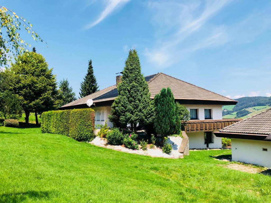 una casa con un patio con césped verde y árboles en Rafael Kaiser Residence Privée - Spielberg Obdach, en Obdach