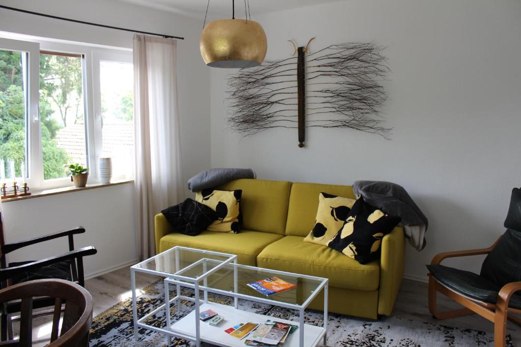 sala de estar con sofá amarillo y mesa en Apartment Rheingold, en Bayreuth