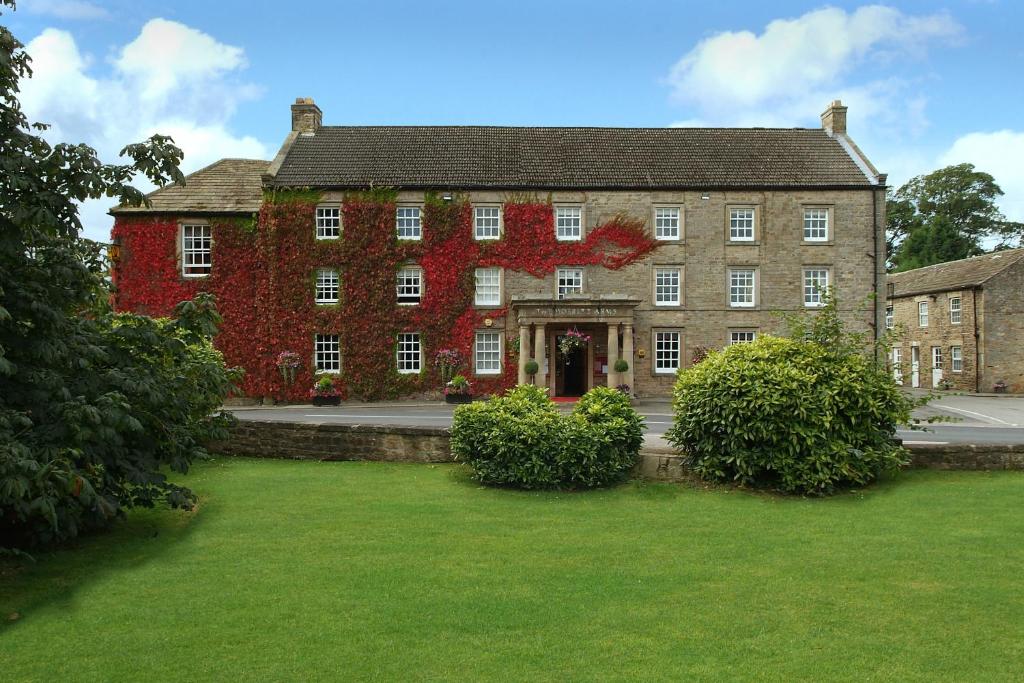 a large brick building with red leaves on it at The Morritt Hotel in Barnard Castle
