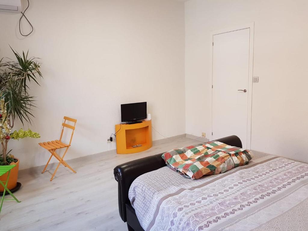 a white room with a bed and a tv at Habitación en Pozuelo de Alarcón in Pozuelo de Alarcón