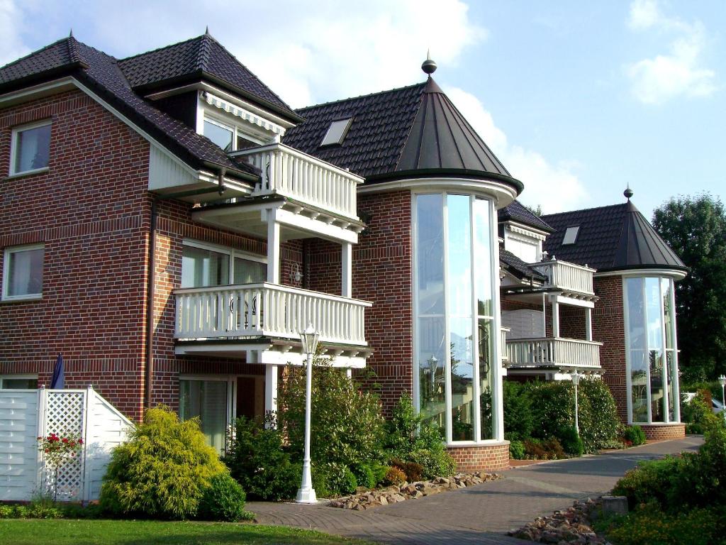 une grande maison en briques avec un toit en gambrel dans l'établissement Ferienwohnungen Mantke SNF zertifiziert, à Gronau