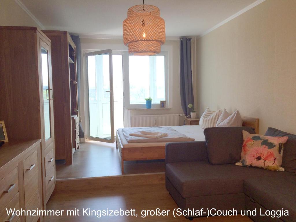 a bedroom with a bed and a couch and a window at Apartment Anna in Chemnitz