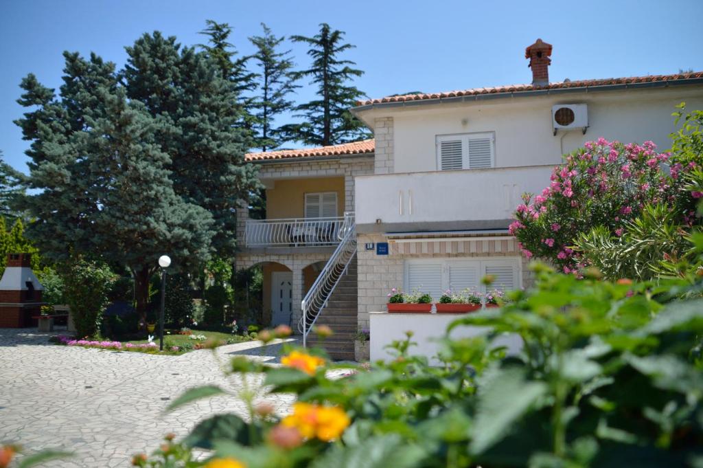 una casa con flores delante en Katy, en Krk