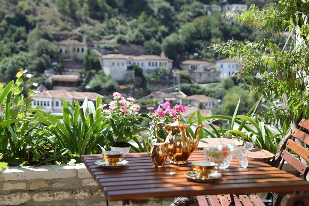 a wooden table with wine glasses and flowers on it at Hani i Xheblatit in Berat