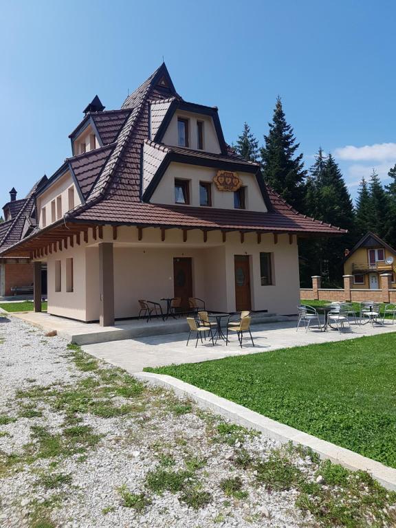 a building with a roof with tables and chairs at Vila Tri Srca in Beserovina