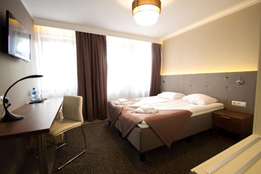 a hotel room with a bed and a desk at Hotel Kolorowa in Karpacz