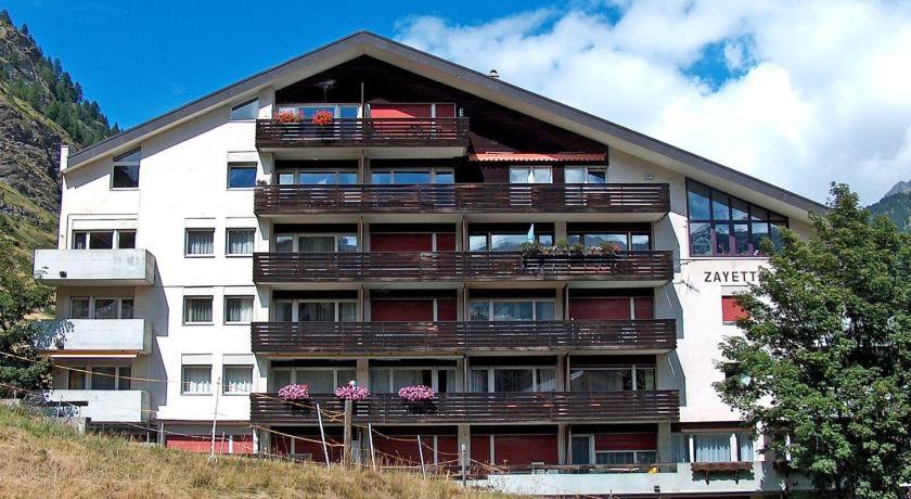 a large building with balconies on top of a hill at Apartment Zayetta in Zermatt
