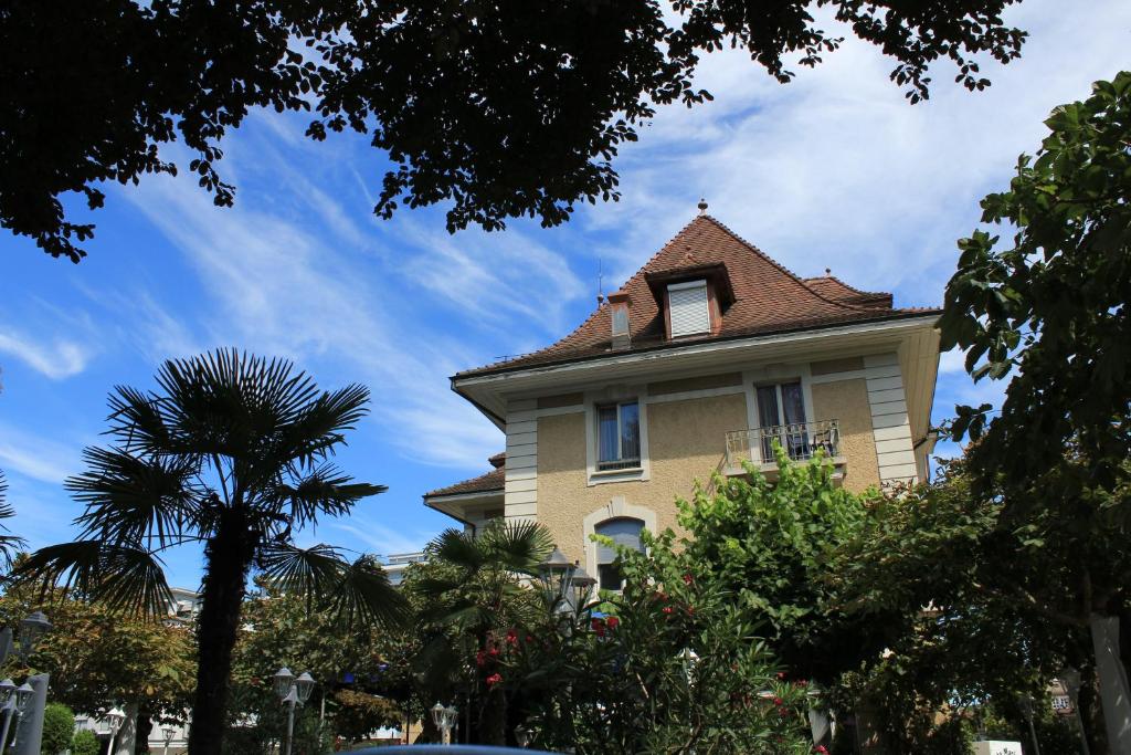 uma casa amarela com telhado de azulejo em Hotel Central em Sursee