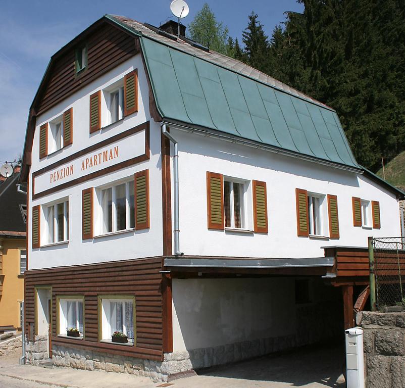 a large white building with a green roof at Penzion Apartmán Janov in Janov nad Nisou