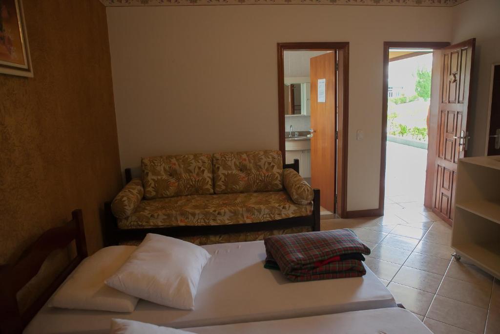 a living room with a couch and a bed at Pousada Recanto Feliz Itatiba in Itatiba