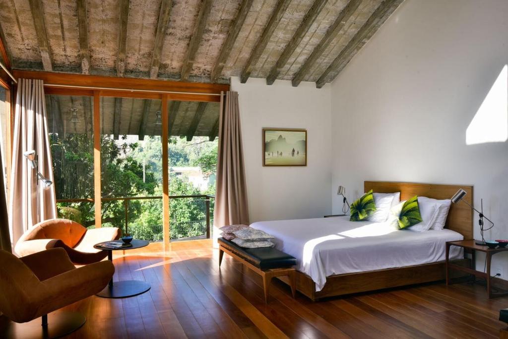 a bedroom with a bed and a large window at Chez Georges in Rio de Janeiro