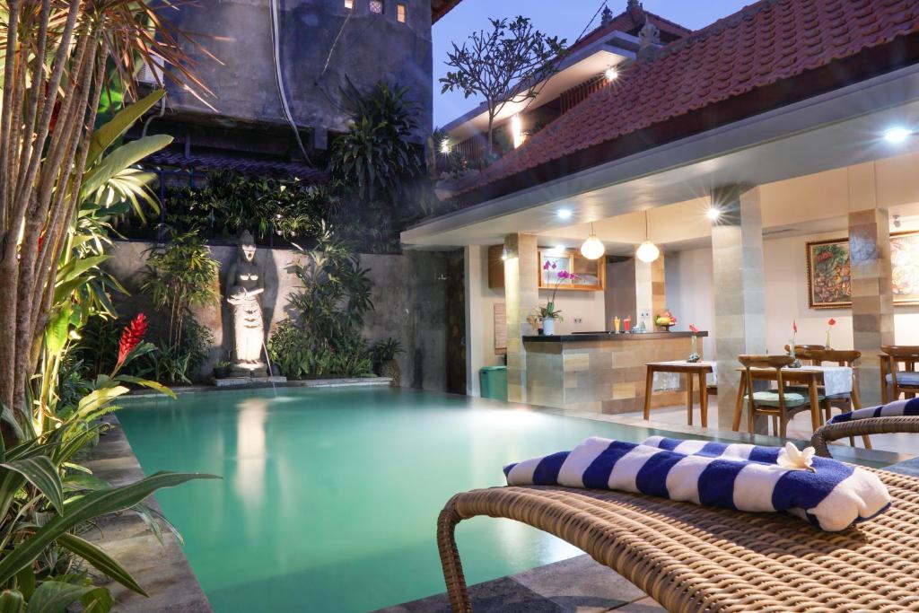 una piscina con panchina accanto a una casa di Narada House Ubud ad Ubud
