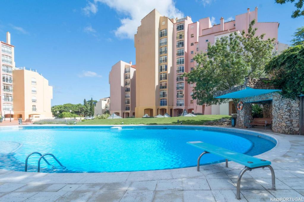 a swimming pool in front of a building at Gandarinha Residence in Cascais