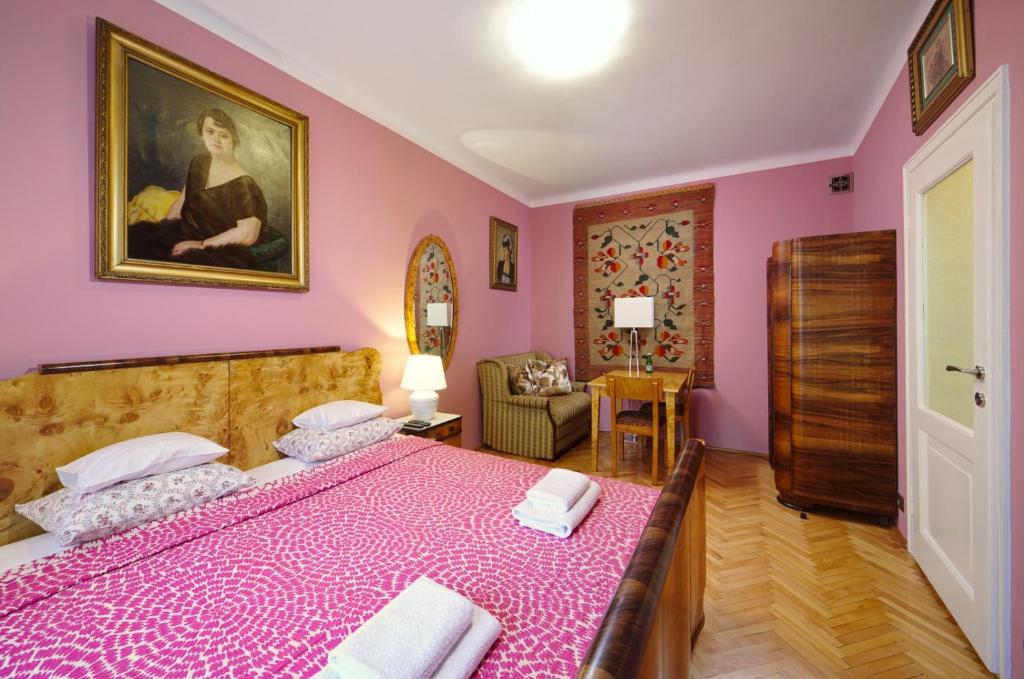ワルシャワにあるApartament Polski Free Guarded Parkingのピンクの壁のベッドルーム(大型ベッド1台付)