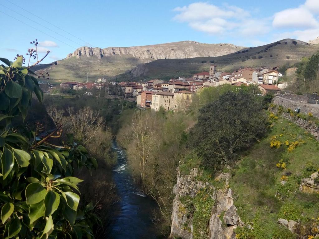 uma pequena cidade num rio com montanhas ao fundo em Casa Petra y Armando em Anguiano