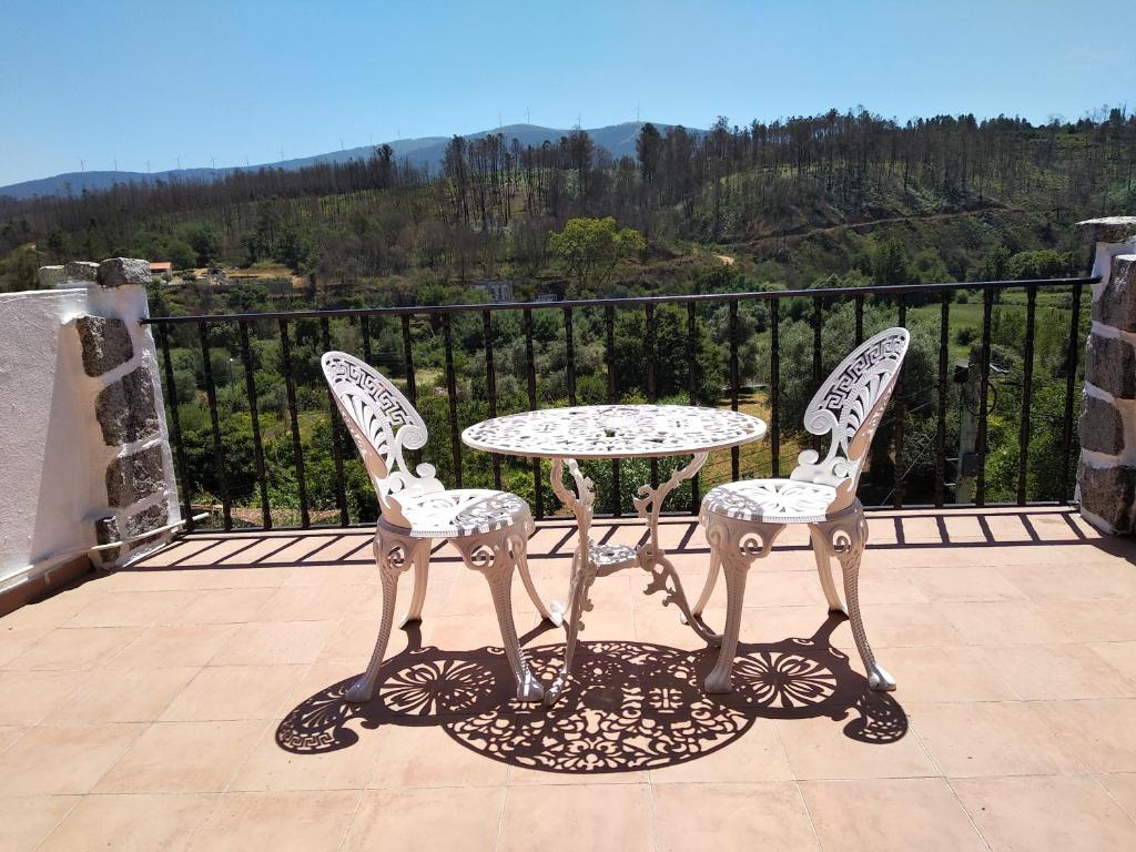 einen Tisch und zwei Stühle auf einem Balkon in der Unterkunft Casa da Eira in Lousã