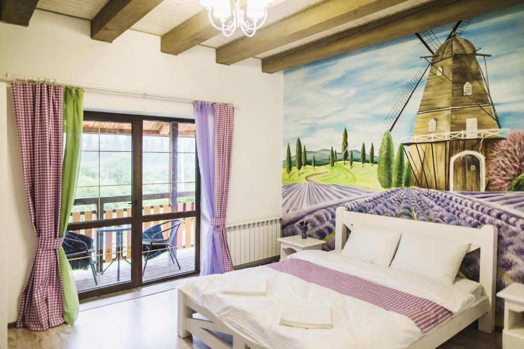 1 dormitorio con un mural de un molino de viento en Pogar Inn en Slavske