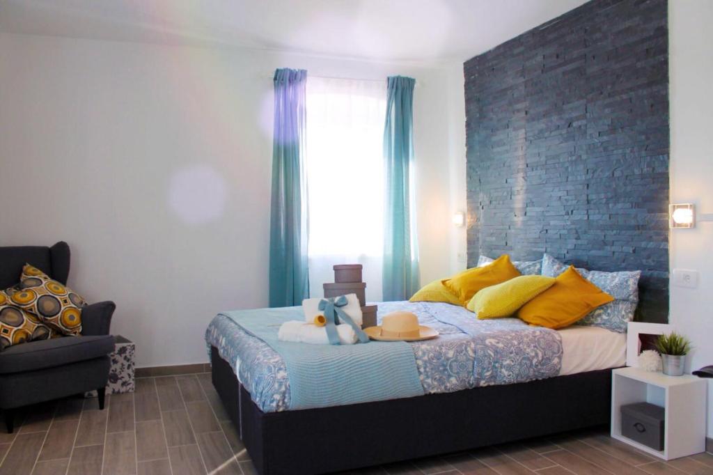 a bedroom with a bed with yellow pillows and a window at Apartments Borghetto in Vinkuran