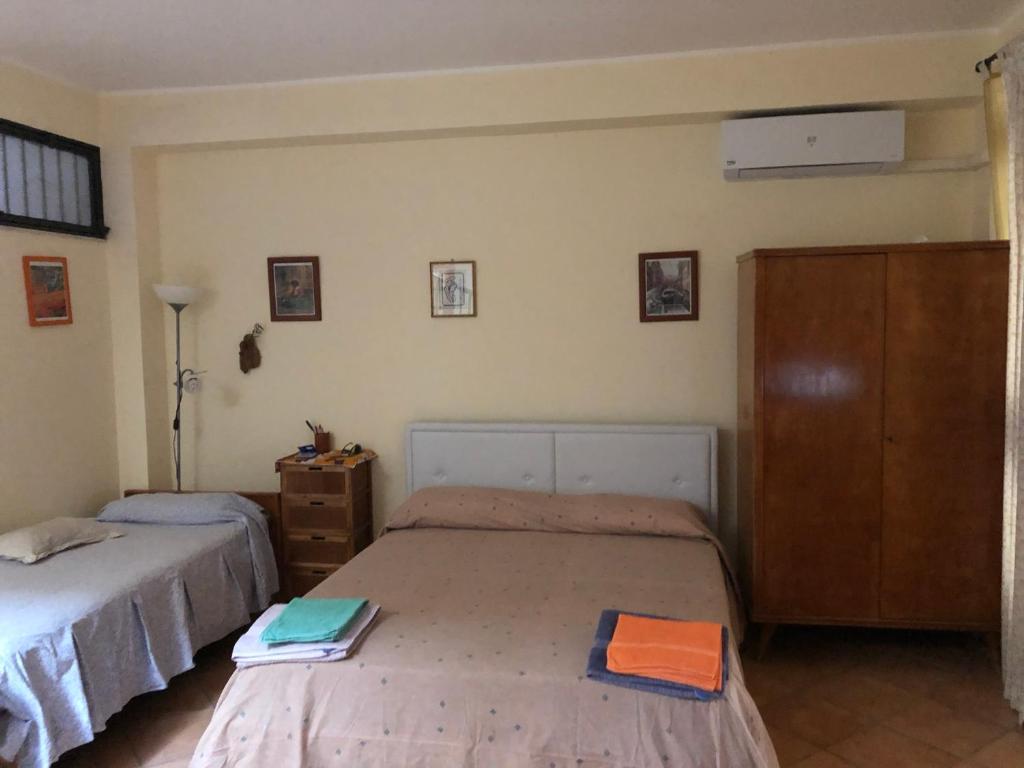 a bedroom with two beds and a dresser at Cozy Apartment by the Sea in Acireale