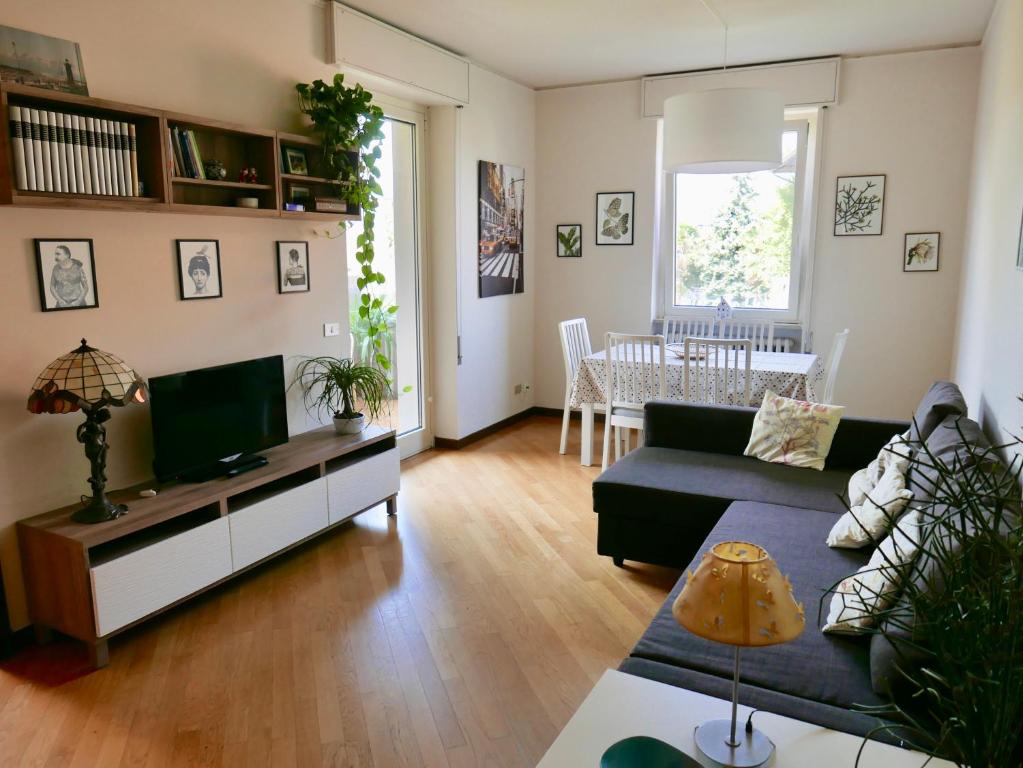 uma sala de estar com um sofá e uma televisão em Horto Terapeutico Home em Desenzano del Garda