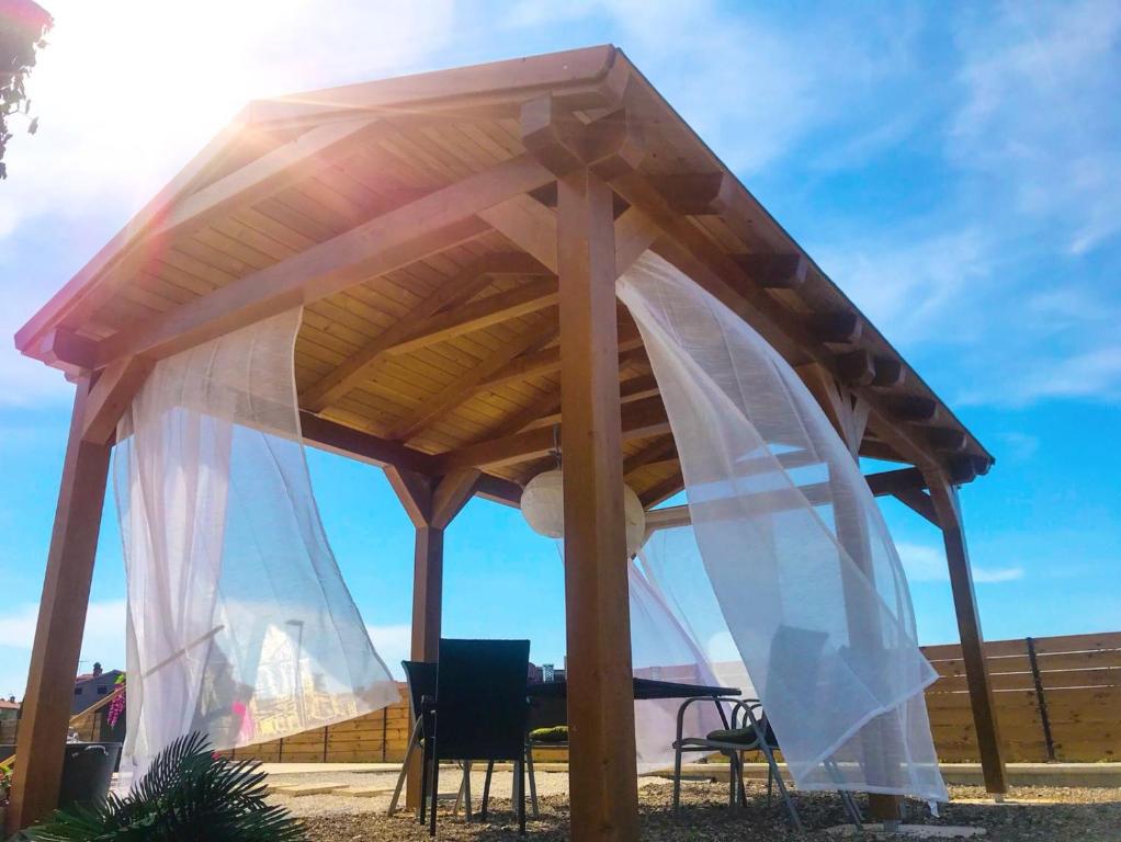 a wooden pergola with a table and chairs under it at Apartments Borghetto in Vinkuran