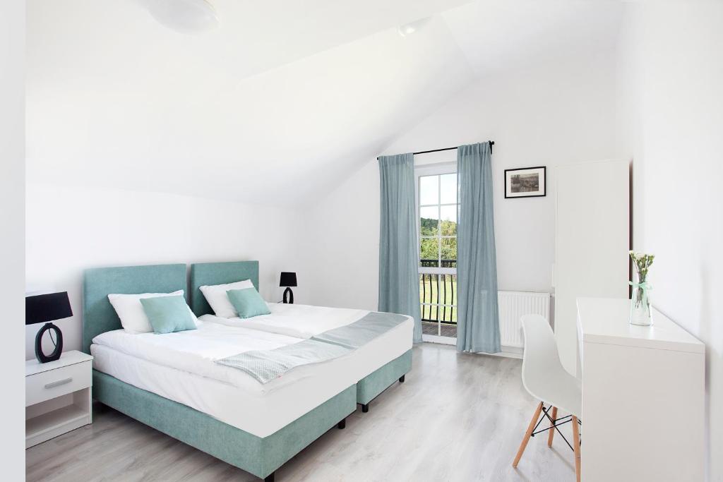 a bedroom with a bed and a desk and a window at Apartamenty Góra in Wejherowo