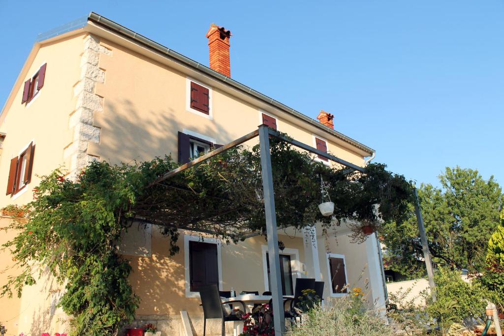 a house with vines growing on the side of it at Apartments Borghetto in Vinkuran